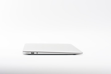 Closed  modern, new laptop on white background, side view.