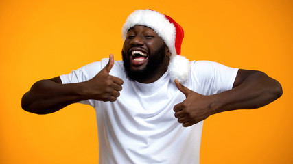 Excited African-American Santa man showing thumbs up, Happy Christmas holidays