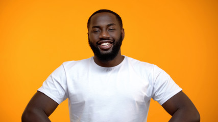 Happy Afro-American male smiling at camera isolated on yellow background