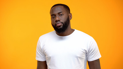 Upset African-American man looking at camera isolated on yellow background
