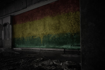 painted flag of bolivia on the dirty old wall in an abandoned ruined house