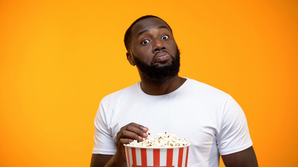 African-American male with popcorn watching science TV show, new knowledge