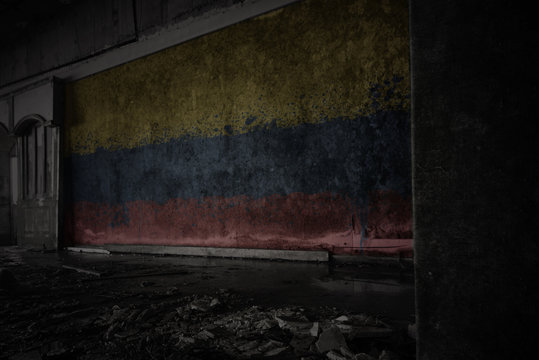painted flag of colombia on the dirty old wall in an abandoned ruined house