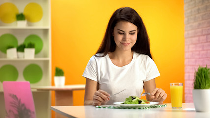 Obraz na płótnie Canvas Female vegetarian eating fresh salad sitting cafe, orange juice glass on table
