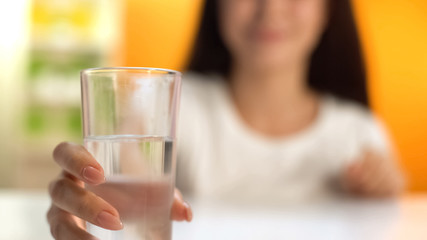 Woman holding fresh water, body hydration, beverage for weight loss, refreshment