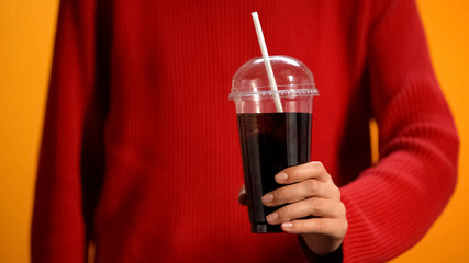 Female holding sweet soda beverage, unhealthy but tasty drink, refreshing
