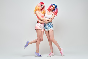 Fashion. Two Inspired woman smiling. Shapely joyful sister friend hugging Having Fun, Stylish...
