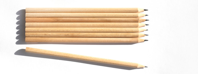 Obraz premium 8 pencils are on the table in bright daylight. Natural unpainted wood. Eco-friendly materials. Not like everyone else