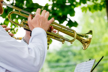 The musician plays the trumpet during an outdoor concert_