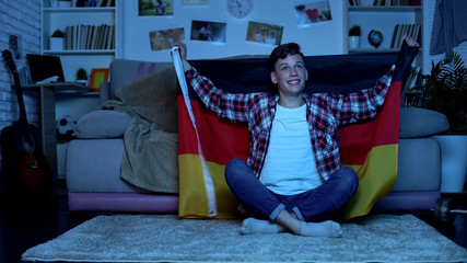 Teenager with German flag cheering national football team, sports competition