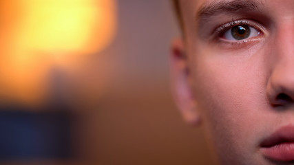 Handsome teenage boy looking directly to camera, background, half-face close-up