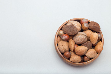 Hazelnut, walnut, almond and brazil nuts in wooden bowl, horizontal, copy space