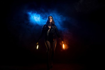 Fototapeta na wymiar Brunette in black jacket with torches shot