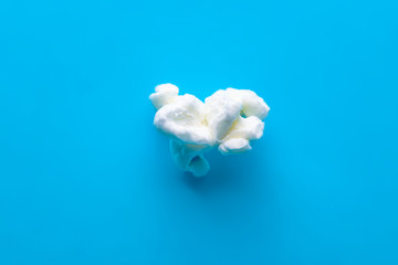 Fototapeta na wymiar Popcorn on a blue background. Macro image of popcorn