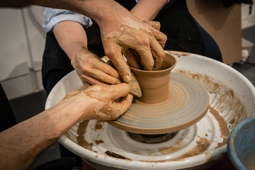 Expert potter teach a woman to work on potter wheel