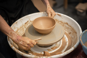 Expert potter teach a man to work on potter wheel