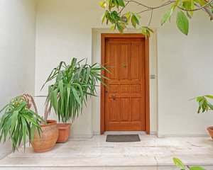 cozy house entrance solid wooden door and flower pots