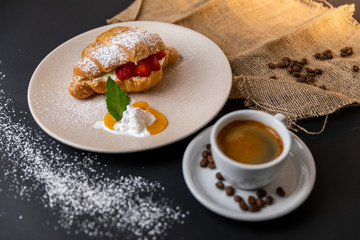 Breakfast with fresh croissants, cup of coffee and strawberry jam on a Black background, Slow-mo