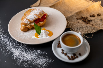 Breakfast with fresh croissants, cup of coffee and strawberry jam on a Black background, Slow-mo