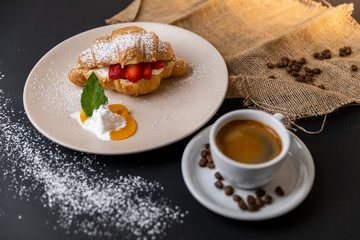 Breakfast with fresh croissants, cup of coffee and strawberry jam on a Black background, Slow-mo