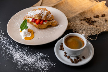 Breakfast with fresh croissants, cup of coffee and strawberry jam on a Black background, Slow-mo