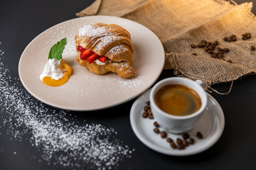 Breakfast with fresh croissants, cup of coffee and strawberry jam on a Black background, Slow-mo