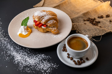 Breakfast with fresh croissants, cup of coffee and strawberry jam on a Black background, Slow-mo