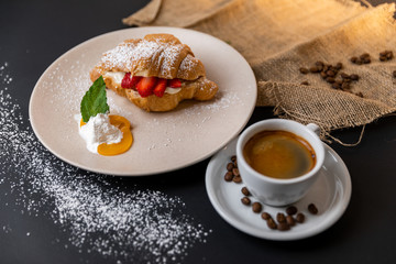 Breakfast with fresh croissants, cup of coffee and strawberry jam on a Black background, Slow-mo
