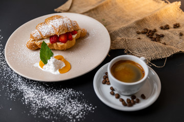 Breakfast with fresh croissants, cup of coffee and strawberry jam on a Black background, Slow-mo