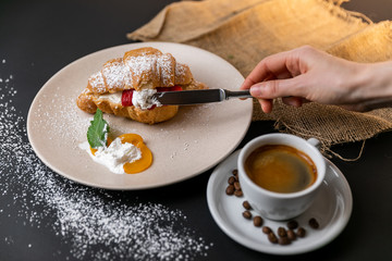 Breakfast with fresh croissants, cup of coffee and strawberry jam on a Black background, Slow-mo