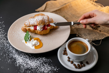 Breakfast with fresh croissants, cup of coffee and strawberry jam on a Black background, Slow-mo