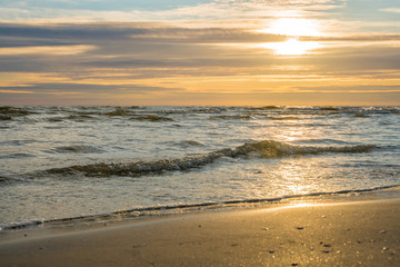 Fototapeta na wymiar   Very beautiful golden sunset on the sea, golden waves and the golden coast.