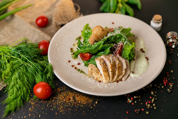 Healthy Grilled Chicken Caesar Salad with Cheese and Croutons. Healthy food, top view. Black background . Slow-mo