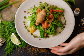 Healthy salad plate. Fresh seafood recipe. Grilled shrimps and fresh vegetable salad and egg. Grilled prawns. Healthy food. Flat lay. Top view. Black background . Slow-mo.