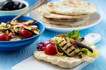 Grilled eggplant, tomatoes and feta cheese salad with flatbread, mediterranean cuisine.