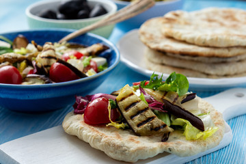 Grilled eggplant, tomatoes and feta cheese salad with flatbread, mediterranean cuisine.