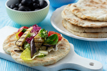 Grilled eggplant, tomatoes and feta cheese salad with flatbread, mediterranean cuisine.