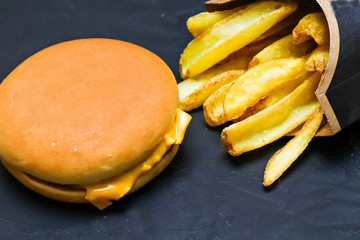 potato chips and cheeseburger on a black background.