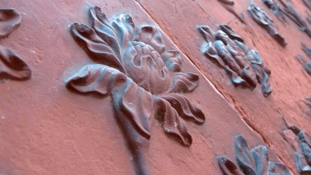 Amazing carved red sandstone walls by floral pattern of the historical Taj Mahal - a mausoleum mosque, Agra, India. Shot in motion