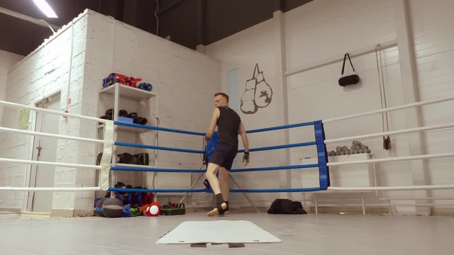 Two young professional fighters do a bunch of exercises in turn acrobatic cartwheel and tumbling back on ringside in fight club. Intensive professional sport training.