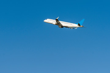 A huge commercial air plane just departure and flying on the blue sky.