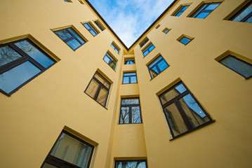 Fototapeta premium Looking up a yellow apartment building.
