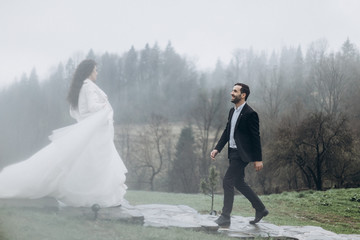 young couple of men and women during a wedding photo shoot in the mountains. Attractive bride and groom, perfect wedding couple