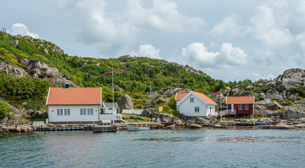 Two white wooden houses by the sea.