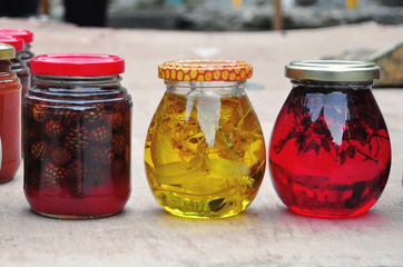 Transparent multi-colored jars of red and yellow jam
