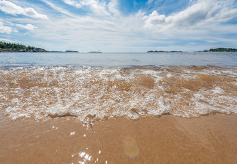 Waves on a sunny, sand beach.