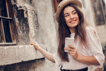 Beautiful woman traveler  using phone walking on the old town street.