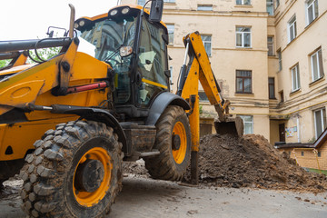 The excavator digs a trench for repair work on the heating main.