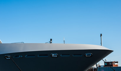 The bow of a grey yacht at port.