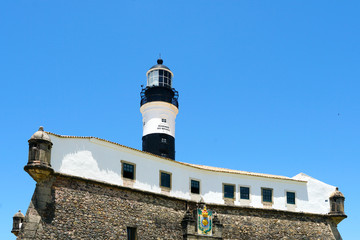 Farol da Barra (Barra Lighthouse) in Salvador, Bahia, Brazil.  The historic architecture of Salvador in Bahia, the Farol da Barra Lighthouse at Bahia de Todos os Santos Bay.